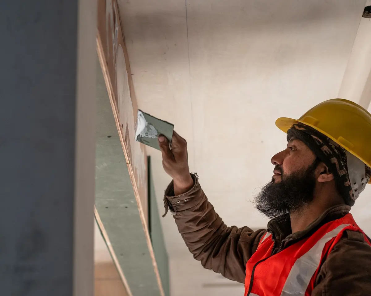A drywall finisher working on a ceiling