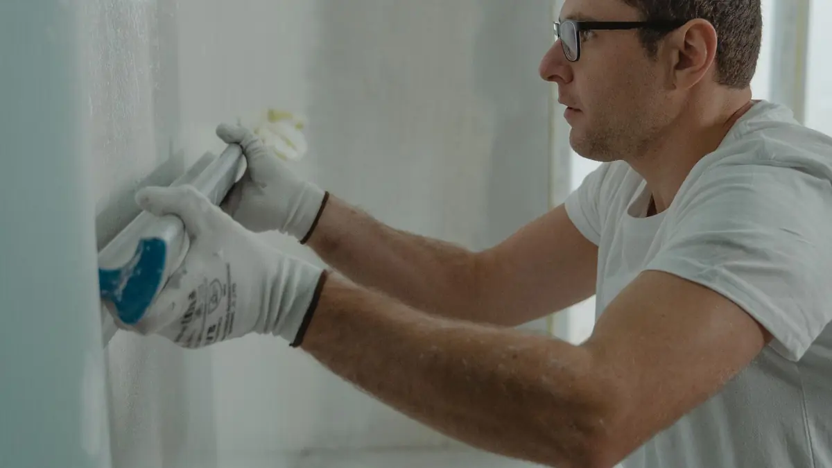 A finisher taping and coating drywall joints